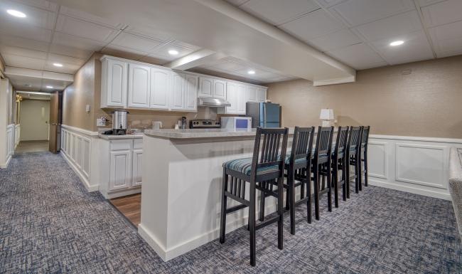 a kitchen with a bar and chairs